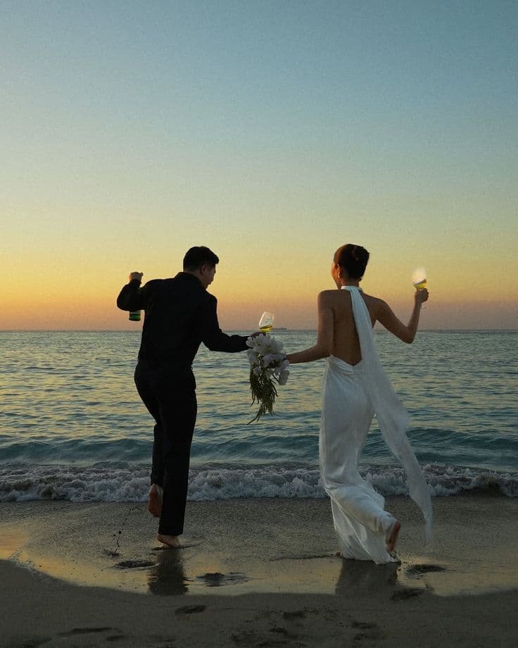 Couple celebrating at beach wedding sunset