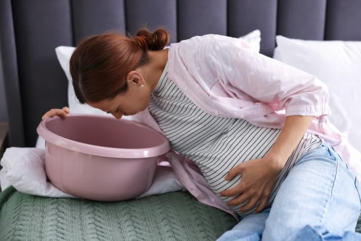 first trimester pregnancy tips - woman resting on couch with pregnancy symptoms
