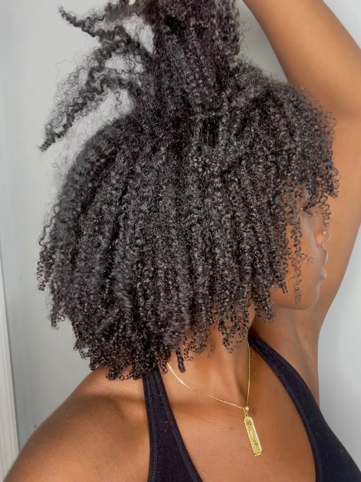 a lady lifting some of her 4C Hair up with her left hand