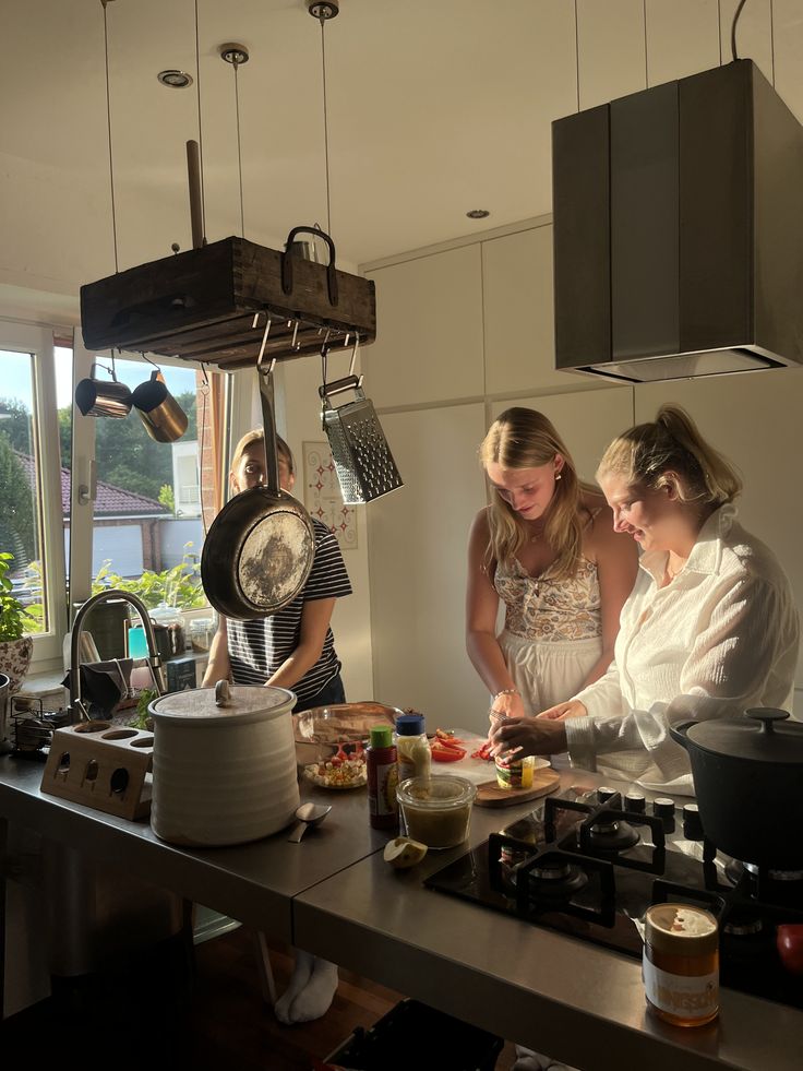 three ladies in the kitchen preparing a meal