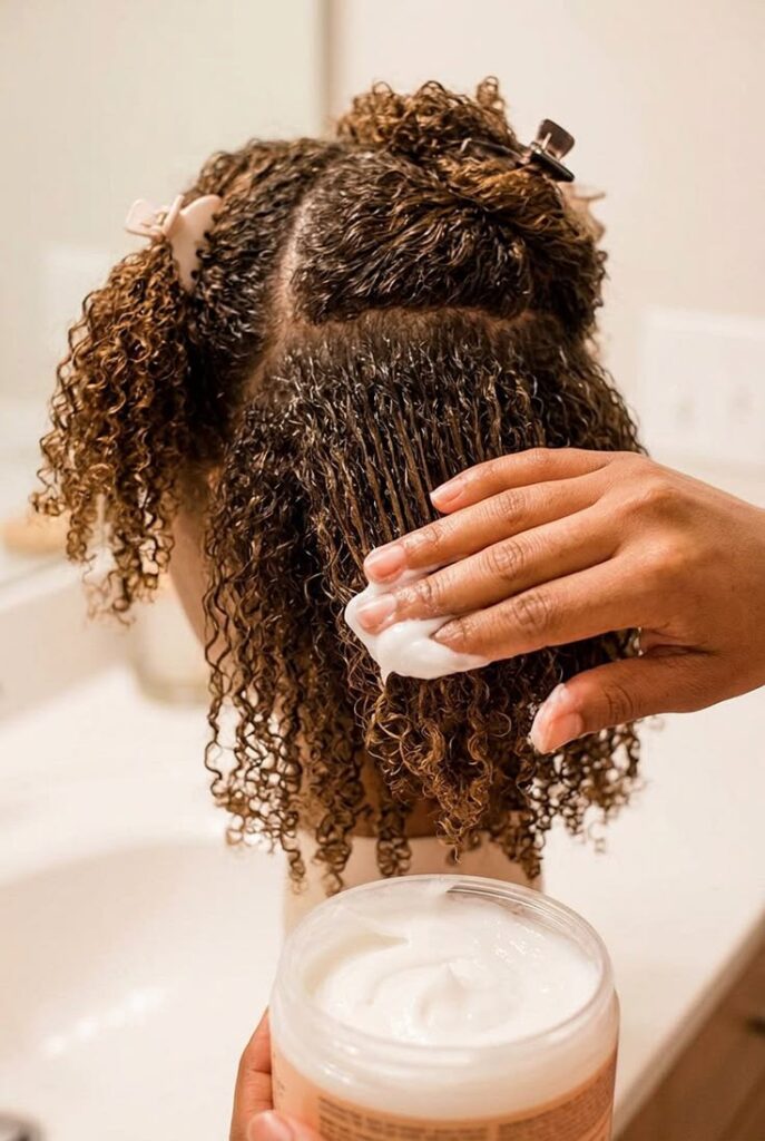 Deep conditioning treatment applied to moisturize and soften coily natural hair