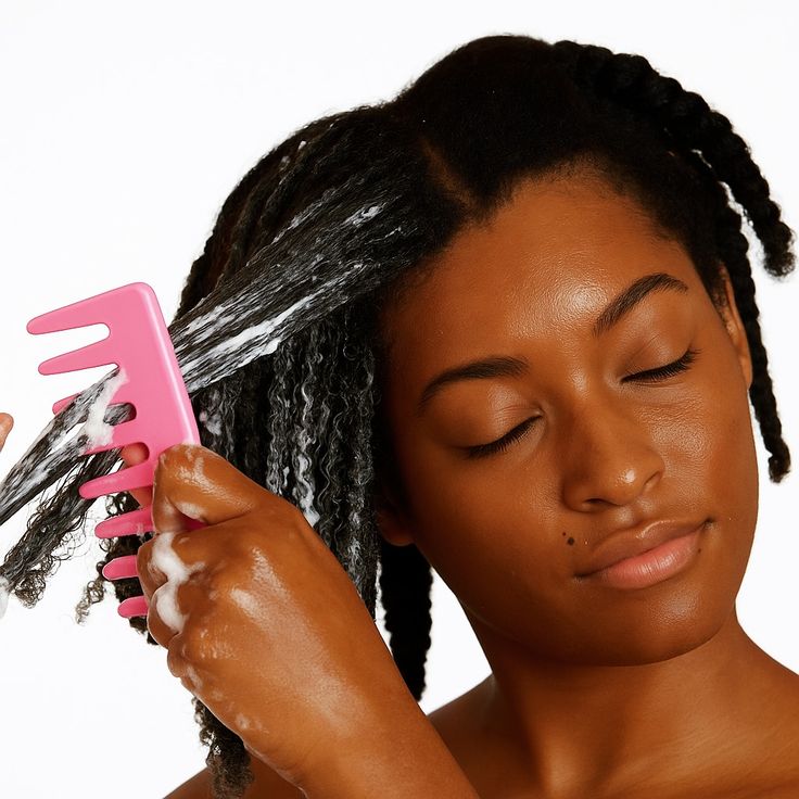 detangling tightly coiled natural hair with wide tooth comb