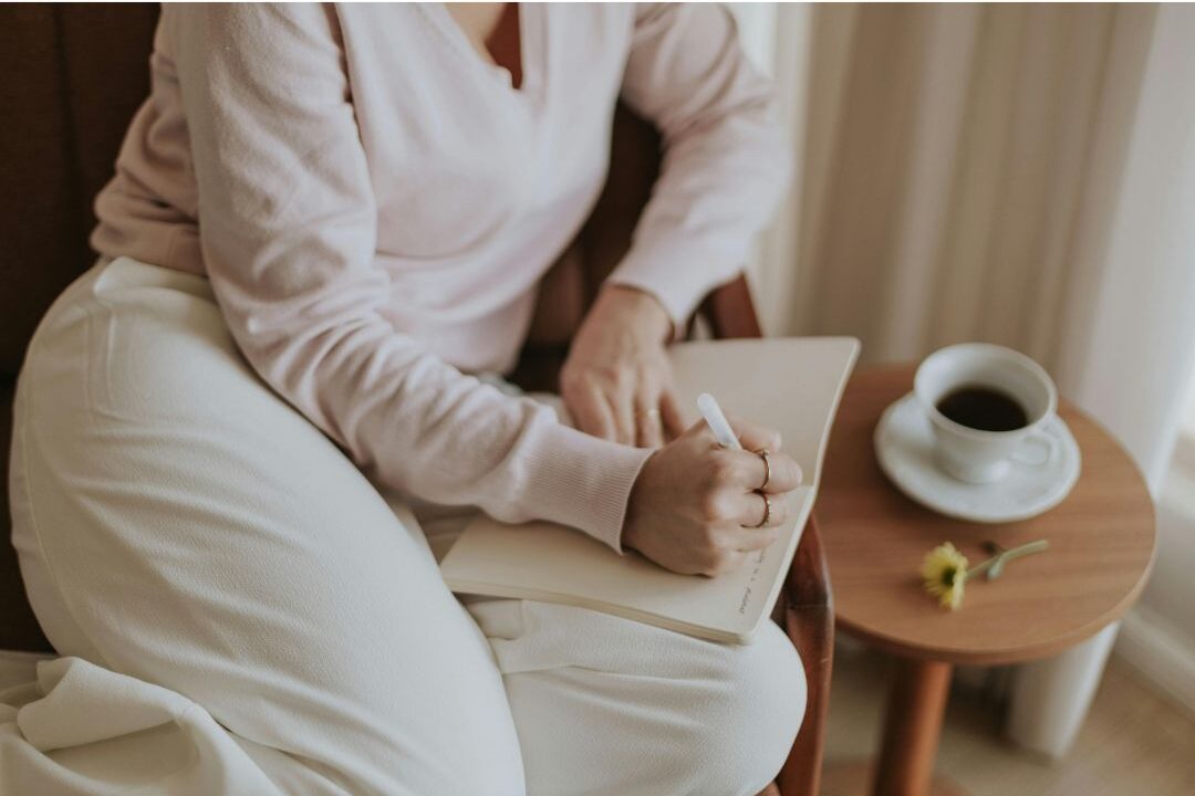 stay at home mom building a gentle daily routine with coffee and a notebook