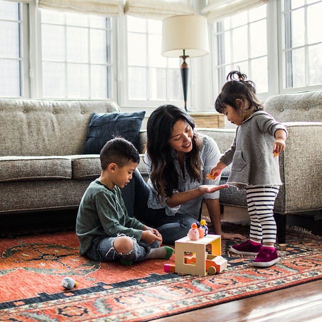 a lady playing with two kids
