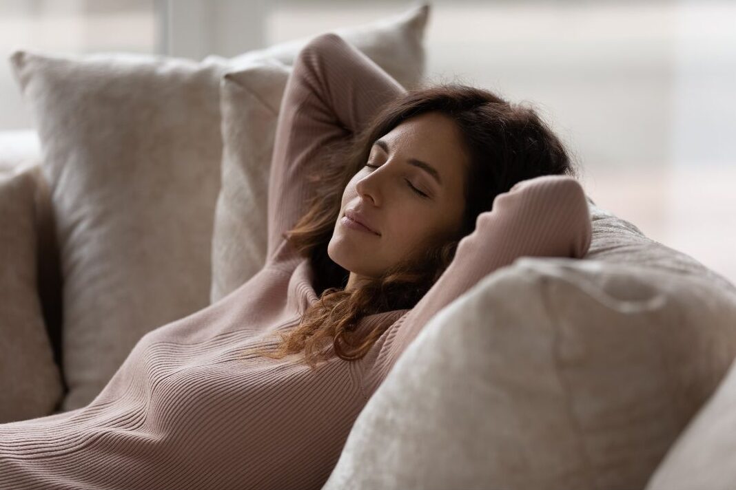 stay at home mom laying her head back, releasing guilt and allowing herself to rest at home