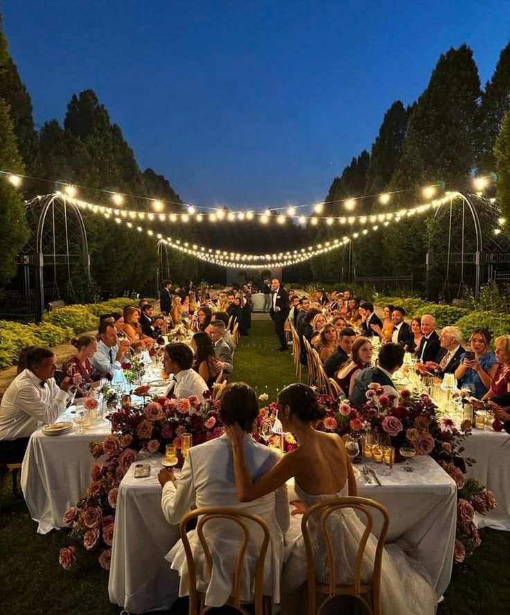 Guests seated in an outdoor decorated space for a wedding reception