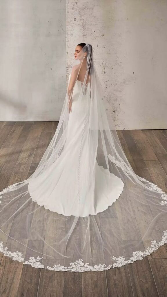 A luxurious ivory ballgown wedding gown featuring corded lace with sequins over ivory tulle and a lavender matte lining.