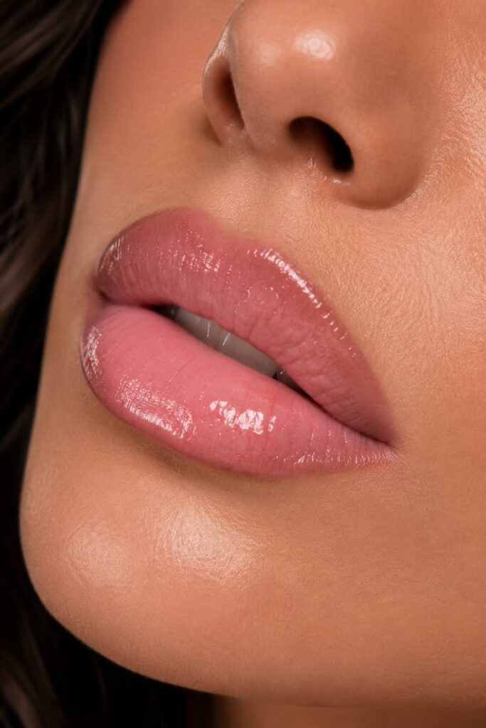 A soft pink lip combo with subtle liner, glossy nude shine, and a fresh natural finish