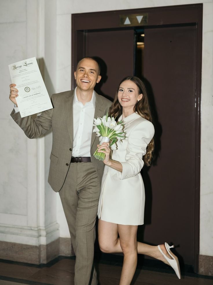 A legally married couple showing off their marriage license