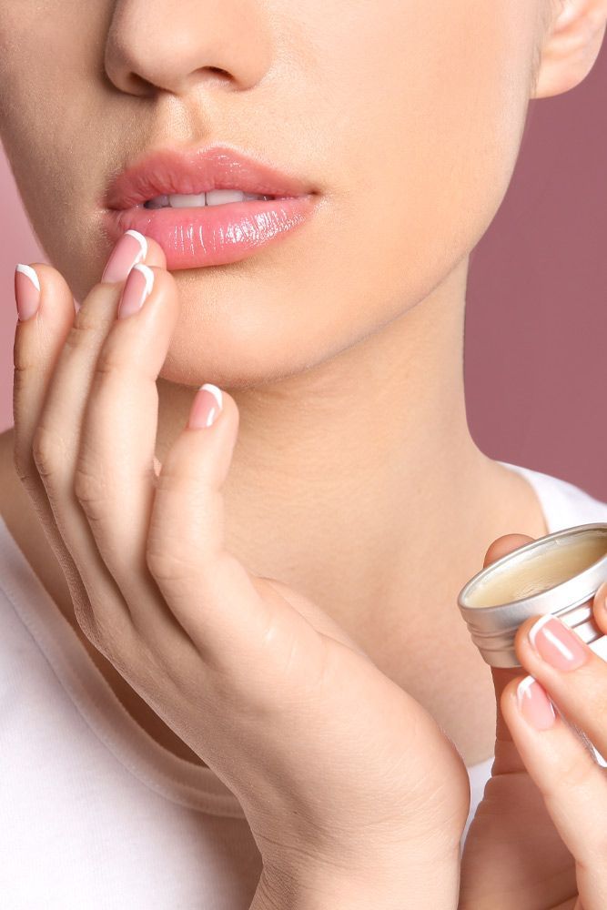 A lady applying a lip balm on her lips