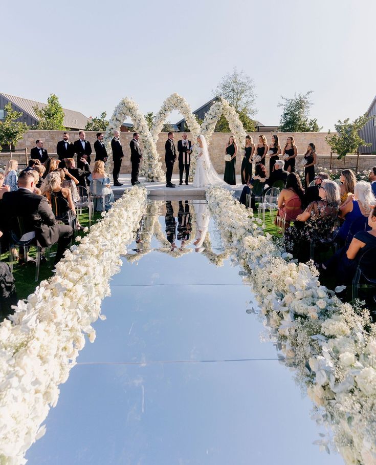 A ceremony featuring a magical mirror aisle adorned with florals, creating an incredible backdrop for this special day.⁠