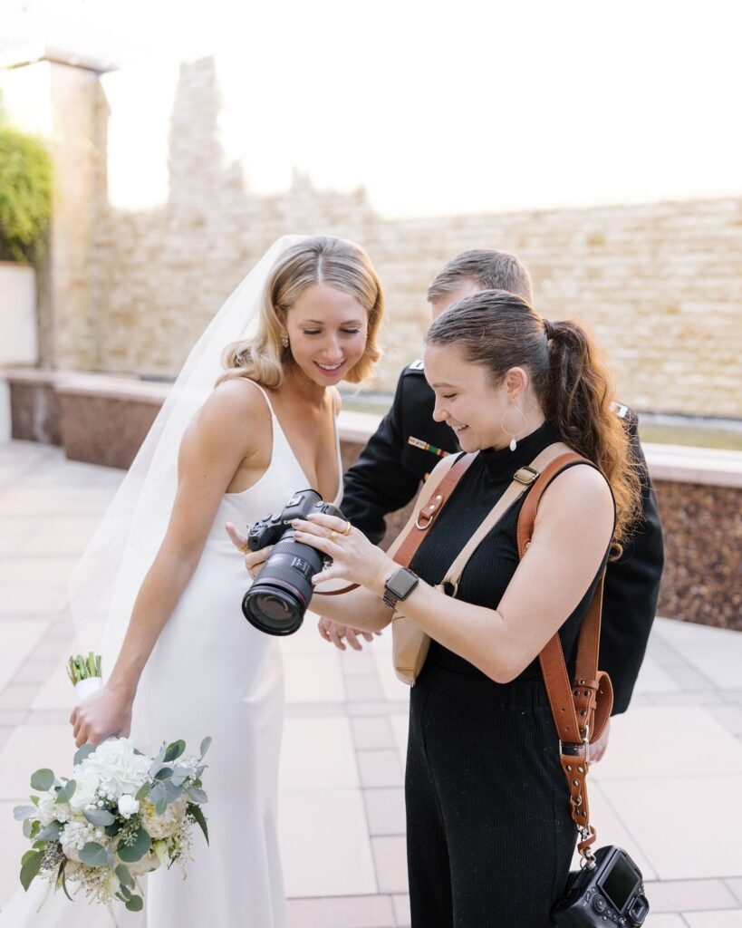 A photographer showing a bride and her groom pictures on her camera