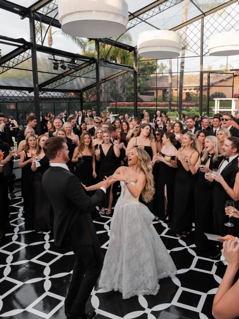 A happy couple dancing and their guests cheering them up