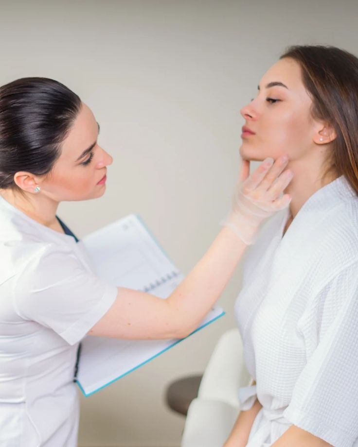 A woman having a session with a female dermatologist as she checks her skin.