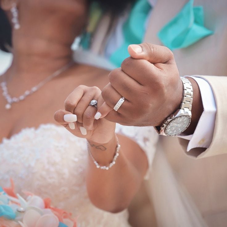 A couple showing off their wedding rings